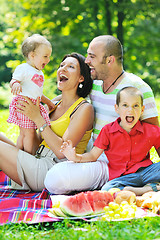 Image showing happy young couple with their children have fun at park