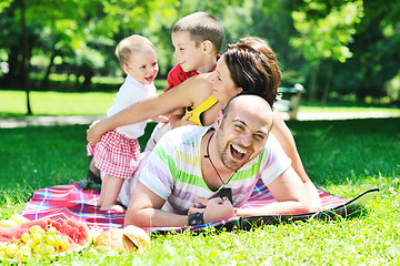 Image showing happy young couple with their children have fun at park