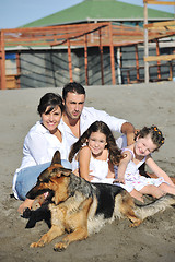 Image showing happy family playing with dog on beach