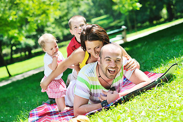 Image showing happy young couple with their children have fun at park