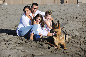 Image showing happy family playing with dog on beach