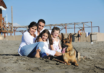 Image showing happy family playing with dog on beach