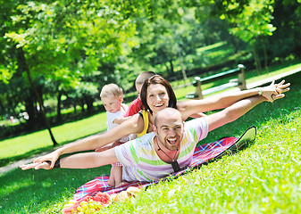 Image showing happy young couple with their children have fun at park