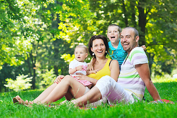 Image showing happy young couple with their children have fun at park