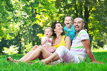 Image showing happy young couple with their children have fun at park