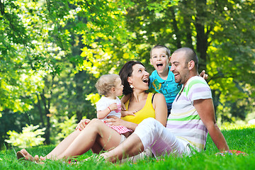 Image showing happy young couple with their children have fun at park