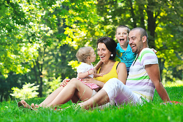 Image showing happy young couple with their children have fun at park