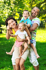 Image showing happy young couple with their children have fun at park