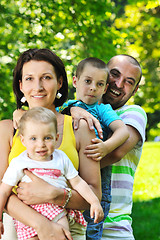 Image showing happy young couple with their children have fun at park