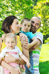 Image showing happy young couple with their children have fun at park