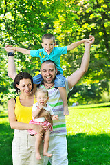 Image showing happy young couple with their children have fun at park