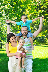 Image showing happy young couple with their children have fun at park