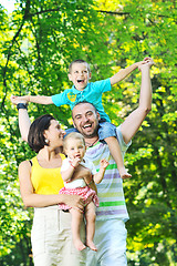 Image showing happy young couple with their children have fun at park