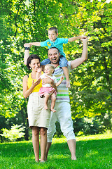 Image showing happy young couple with their children have fun at park