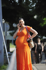 Image showing happy pregnant woman talking by cellphone