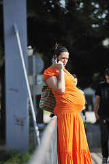 Image showing happy pregnant woman talking by cellphone