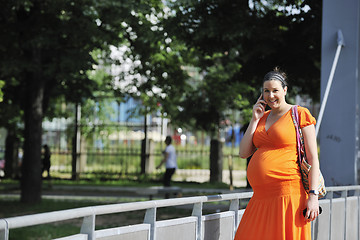 Image showing happy pregnant woman talking by cellphone