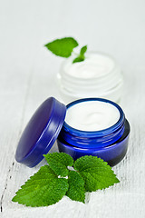 Image showing face cream in jars with urtica leaves