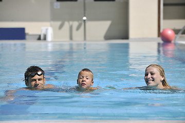 Image showing happy young family have fun on swimming pool