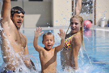 Image showing happy young family have fun on swimming pool