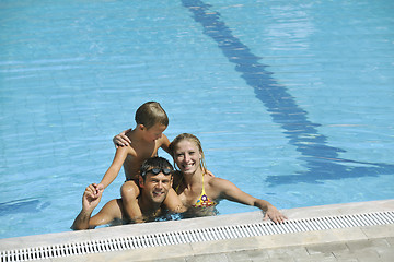 Image showing happy young family have fun on swimming pool