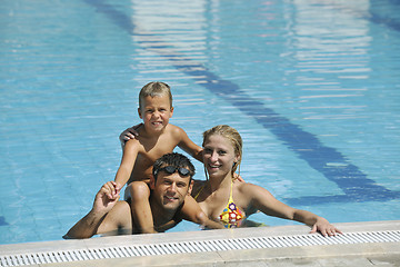 Image showing happy young family have fun on swimming pool