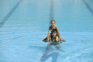 Image showing happy young family have fun on swimming pool