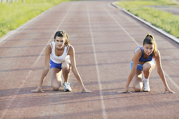 Image showing two girls running on athletic race track