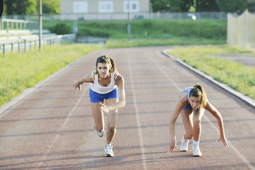 Image showing two girls running on athletic race track