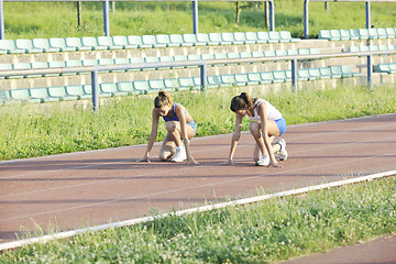 Image showing two girls running on athletic race track