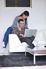 Image showing joyful couple relax and work on laptop computer at modern home