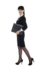 Image showing Cheerful smart business lady walking with files