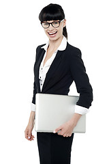 Image showing Cheerful office employee holding laptop