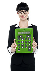 Image showing Pretty female executive showing calculator