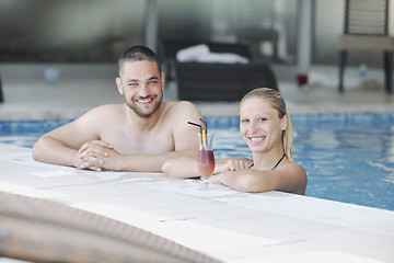 Image showing happy cople relaxing  at swimming pool