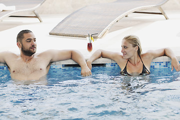 Image showing happy cople relaxing  at swimming pool