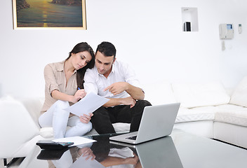 Image showing joyful couple relax and work on laptop computer at modern home