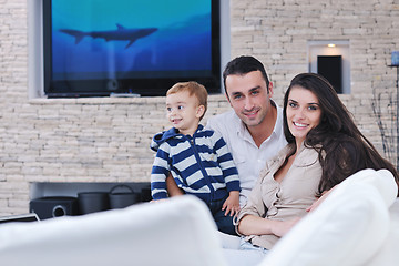 Image showing happy young family have fun  with tv in backgrund