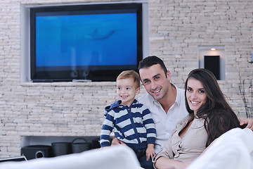 Image showing happy young family have fun  with tv in backgrund