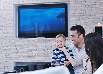 Image showing happy young family have fun  with tv in backgrund