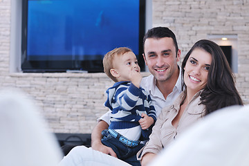 Image showing happy young family have fun  with tv in backgrund