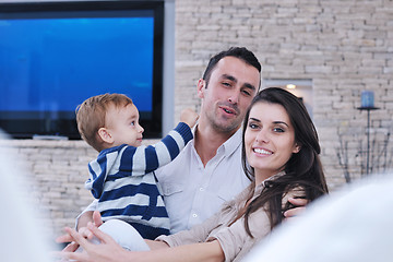 Image showing happy young family have fun  with tv in backgrund