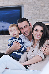Image showing happy young family have fun  with tv in backgrund