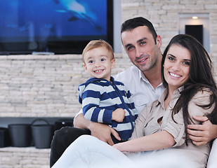 Image showing happy young family have fun  with tv in backgrund