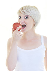 Image showing happy  young  woman eat green apple isolated  on white