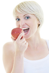 Image showing happy  young  woman eat green apple isolated  on white