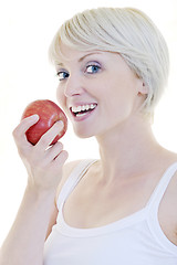 Image showing happy  young  woman eat green apple isolated  on white