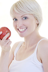 Image showing happy  young  woman eat green apple isolated  on white