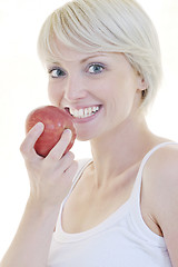 Image showing happy  young  woman eat green apple isolated  on white