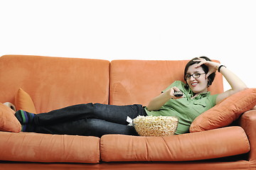 Image showing young woman eat popcorn on orange sofa